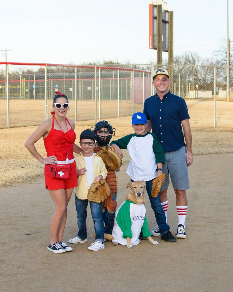 Jim with his family and their dog, dressed in costumes on a baseball field